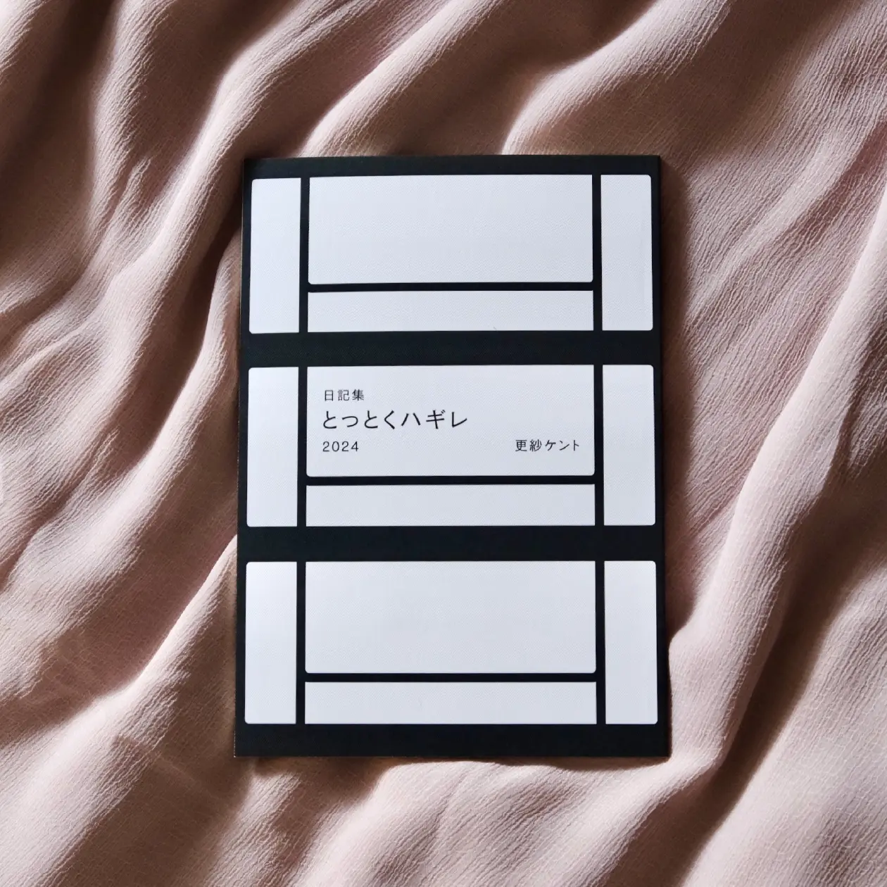 メインビジュアル。布の上に日記集『とっとくハギレ 2024』が表紙を表にして置かれている。